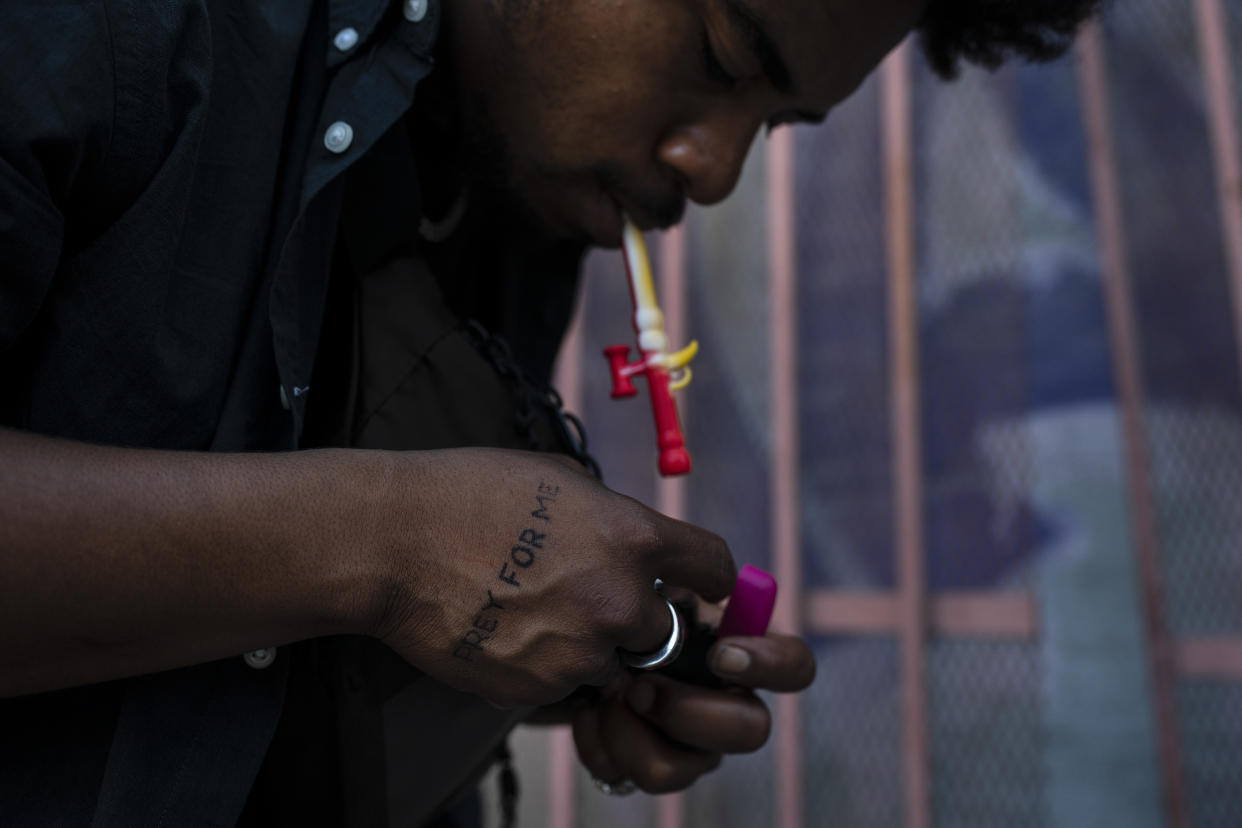 Vino, a 25-year-old drug addict who gave his first name only, smokes fentanyl in an alley in Los Angeles, Wednesday, Sept. 21, 2022. (AP Photo/Jae C. Hong)