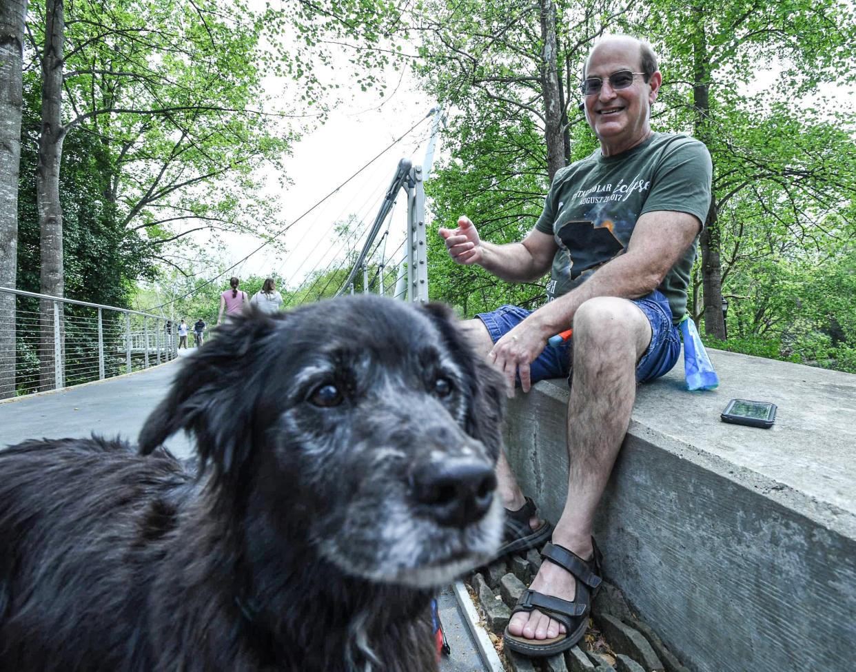 David Gordon of Greenville with Emily his dog at Falls Park at the start of a solar eclipse with viewers in Greenville, S.C. Monday, April 8, 2024. The peak time is estimated 3:08 p.m. "I'm surprised at the lack of foot traffic so far," he mentioned as people start to arrive but in comparison to the 2017 eclipse he viewed in Charlotte.