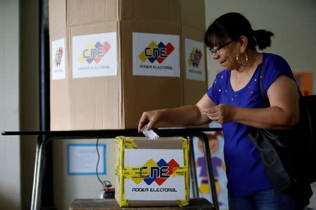 A woman casts her vote in a polling station during a nationwide election for new governors in Caracas, Venezuela, October 15, 2017. REUTERS/Carlos Garcia Rawlins