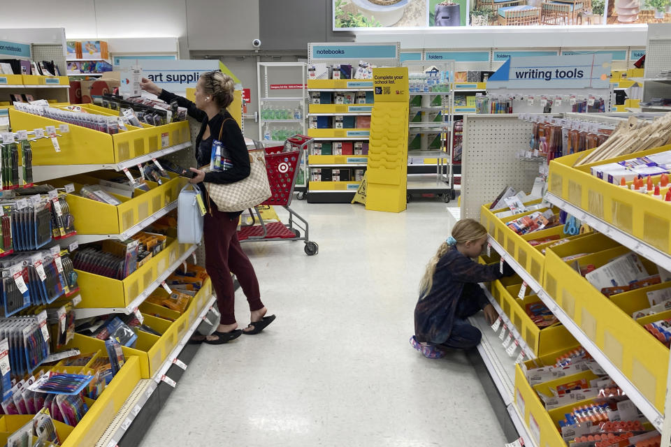 A parent shops for school supplies deals at a Target store, Wednesday, July 27, 2022, in North Miami, Fla. This back-to-school shopping season, parents, particularly in the low to middle income bracket, are focusing on the basics like no frills rainboots, while also trading down to cheaper stores, including second-hand clothing, as surging inflation takes a toll on their household budgets. (AP Photo/Marta Lavandier)