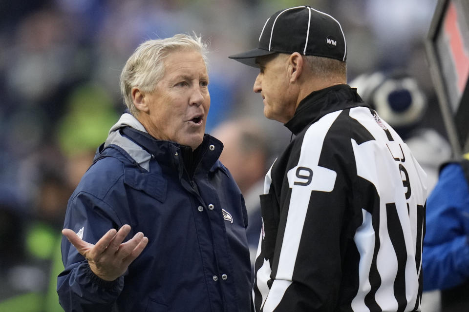 Seattle Seahawks head coach Pete Carroll speaks with line judge Mark Perlman (9) during the first half of an NFL football game against the Carolina Panthers, Sunday, Dec. 11, 2022, in Seattle. (AP Photo/Gregory Bull)