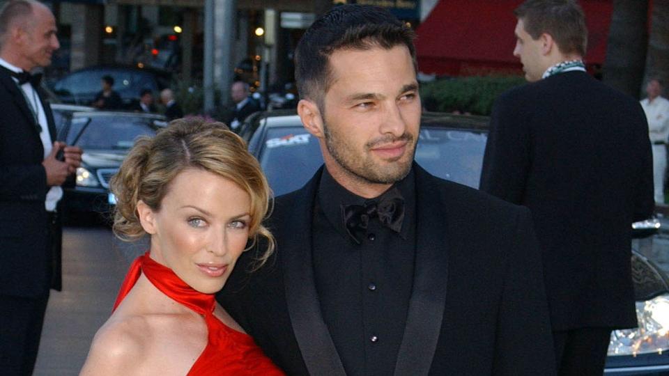 Kylie Minogue in a red dress with Olivier Martinez in a black suit