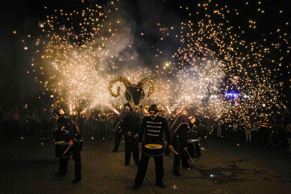 Members of the Basque group "Deabru Beltzak" perform, featuring Aker the devil, drummers, music and fireworks, in Santiago, Chile, Jan. 20, 2024. The groups's . (AP Photo/Esteban Felix)