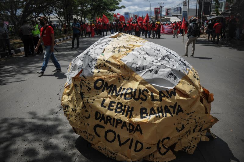 Sign reading "the omnibus bill is more dangerous than COVID" is seen as members of Indonesian trade unions protest against the government's proposed labor reforms in a controversial "jobs creation" bill in Bandung