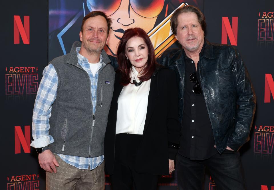 Mike Arnold (left), Priscilla Presley and John Eddie attend the advance screening event photo call for Netflix's "Agent Elvis" at TUDUM Theater on March 7 in Hollywood, Calif.