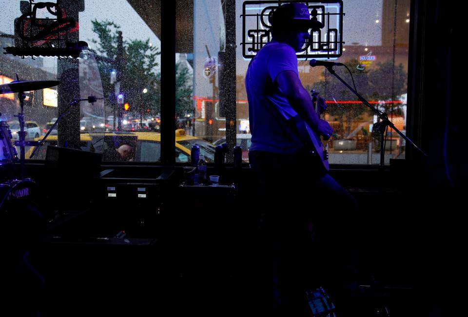 Ethan Ellis plays lead guitar with Blaine Bunting at Legends Corner honkey tonk as rain falls in Downtown Nashville on the fourth day of CMA Fest in Nashville, Tenn., Sunday, June 11, 2023.