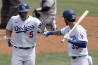 Los Angeles Dodgers' Corey Seager, left, gets congratulations from Cody Bellinger after hitting a solo home run against the Colorado Rockies during the first inning of a baseball game in Los Angeles, Sunday, Aug. 23, 2020. (AP Photo/Alex Gallardo)