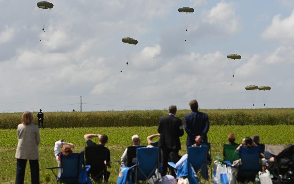 People watch troops drop to the ground