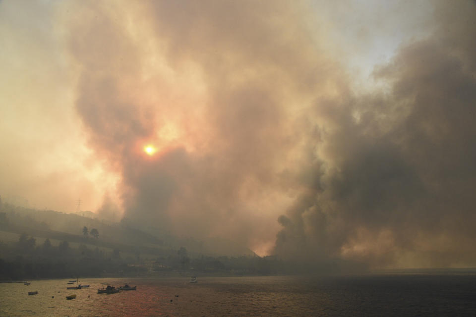 Smoke rises during a wildfire near Lampiri village, west of Patras, Greece, Saturday, Jul. 31, 2021. The fire, which started high up on a mountain slope, has moved dangerously close to seaside towns and the Fire Service has send a boat to help in a possible evacuation of people. (AP Photo/Andreas Alexopoulos)