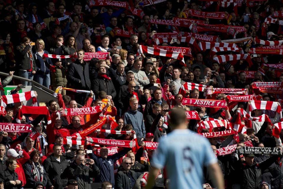 Before their English Premier League soccer match at Anfield Stadium against Manchester City Liverpool supporters hold their scarves prior to a minute's silence in tribute to the 96 supporters who lost their lives in the Hillsborough disaster of 25 years ago on 15 April 1989, Liverpool, England, Sunday April 13, 2014. (AP Photo/Jon Super)