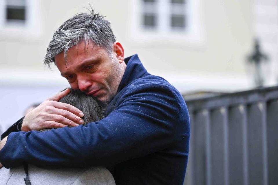 Mourners hug outside the headquarters of Charles University after a mass shooting in Prague, Czech Republic, Friday, Dec. 22, 2023. A lone gunman opened fire at a university on Thursday, killing more than a dozen people and injuring scores of people. (AP Photo/Denes Erdos)
