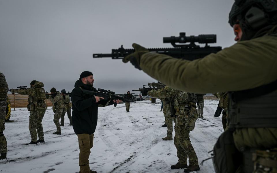 Dimitro Zubkov (center) demonstrates rifle shouldering techniques to his students during a training course in a private training facility in Kyiv Region on December 10, 2022. Ukrainian civilians receive firearms and tactical training in "Backyard Camp", a private training facility operated by Ukrainian and foreign instructors. (Photo by Justin Yau/ The Telegraph) - Justin Yau/ The Telegraph