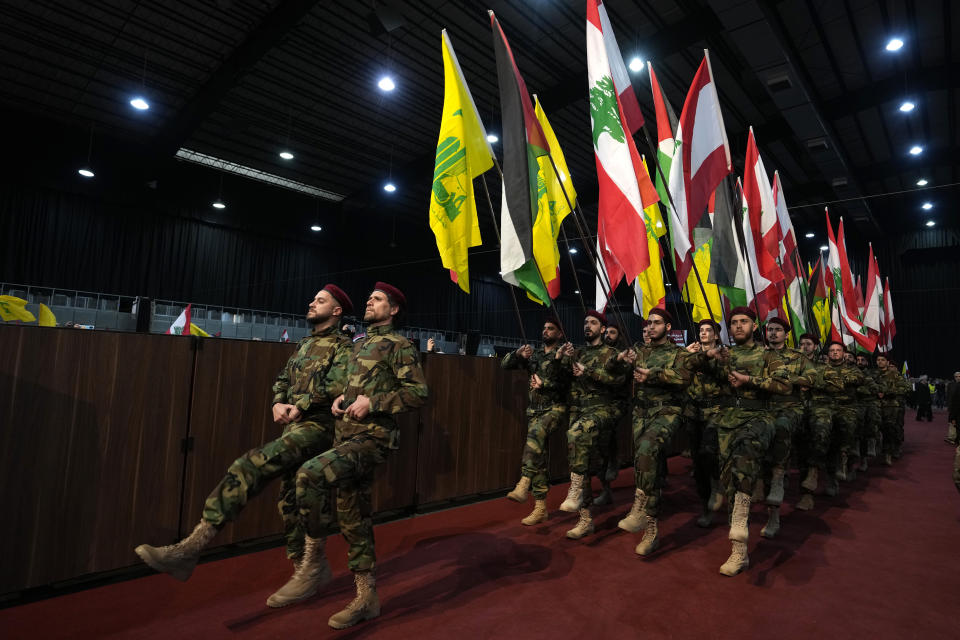 Hezbollah fighters march as hold flags of Lebanon, Palestine and Hezbollah during a rally to mark Jerusalem day or Al-Quds day, in a southern suburb of Beirut, Lebanon, Friday, April 29, 2022. The leader of Lebanon's militant Hezbollah group warned Friday that if Israel continues to target Iran's presence in the region, Tehran could eventually retaliate by striking deep inside Israel. (AP Photo/Hassan Ammar)