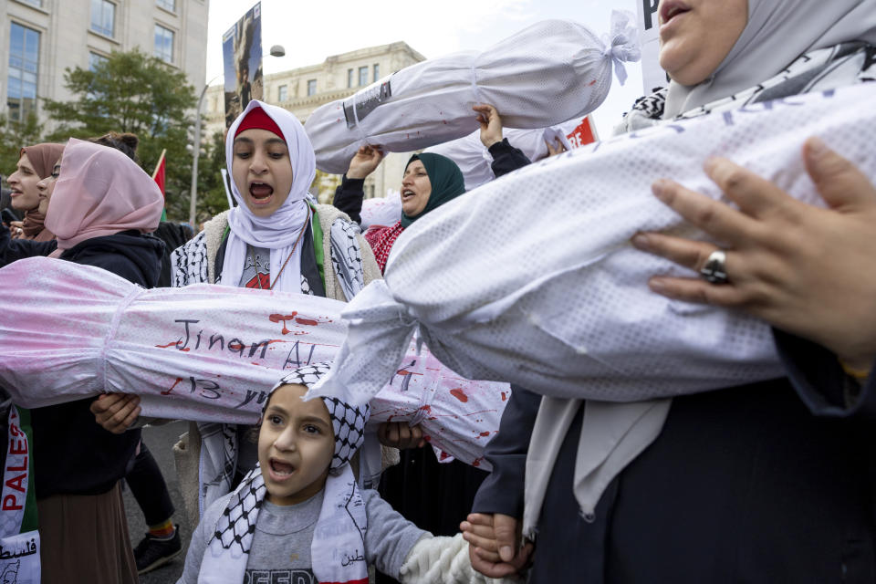 FILE - A family that came with the Islamic Center of Union County in New Jersey holds up effigies of Palestinians who were killed by Israel during a Pro-Palestinian demonstration in Washington on Saturday, Nov. 4, 2023. State lawmakers across the country are expected consider legislation related to the Israel-Hamas war in 2024. (AP Photo/Amanda Andrade-Rhoades, File)