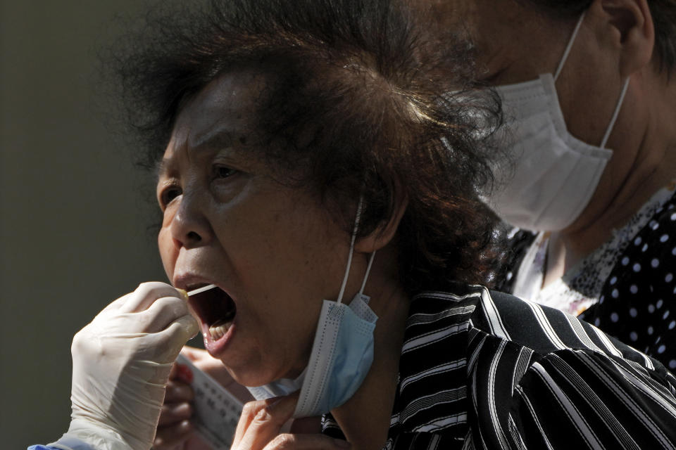 A woman gets her routine COVID-19 throat swab at a coronavirus testing site in Beijing, Monday, Sept. 5, 2022. (AP Photo/Andy Wong)