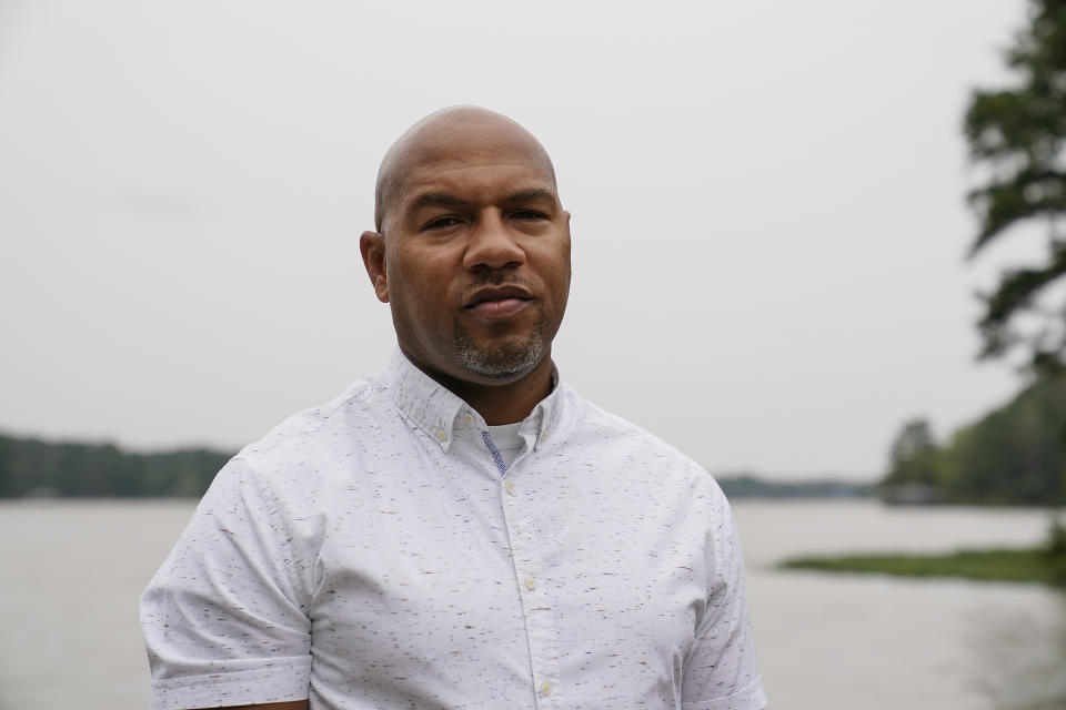 Hancock County coroner Adrick Ingram, 44, of Sparta, poses for a portrait on a deck next to a lake, Saturday, Sept. 19, 2020, in Sparta, Ga. The number of COVID-19 deaths in Hancock County is the highest per-capita rate of any U.S. county. ''It has affected our community in a way that I consider tragic," Ingram says. (AP Photo/Brynn Anderson)