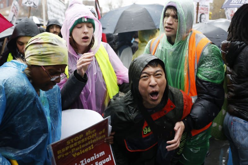 A person is escorted out as protesters hold signs and umbrellas when rain falls at the Hands Off Rafah Ceasefire Now Stop The Genocide protest in response to the IsraeliÐPalestinian conflict in Washington Square Park on Saturday, March 2, 2024 in New York City. Photo by John Angelillo/UPI