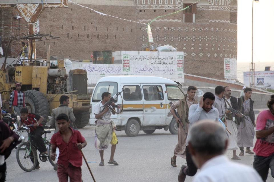 Houthi fighters open fire into the air as they chase anti-Houthi protesters in Houdieda