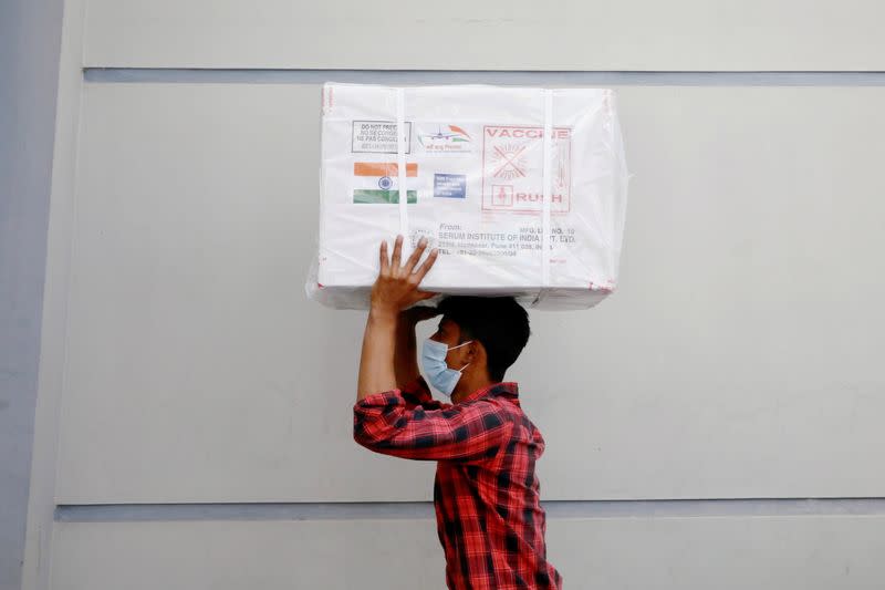 A worker carries a package of Oxford-Astrazeneca COVID-19 vaccines that arrived from India as a gift to Bangladesh, in Dhaka