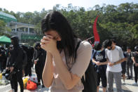 Protesters pause for a moment of silence after disrupting a graduation ceremony at the University of Science and Technology and turning the stage into a memorial venue for Chow Tsz-Lok in Hong Kong on Friday, Nov. 8, 2019. Chow, a student from the University who fell off a parking garage after police fired tear gas during clashes with anti-government protesters died Friday, in a rare fatality after five months of unrest that intensified anger in the semi-autonomous Chinese territory. (AP Photo/Kin Cheung)