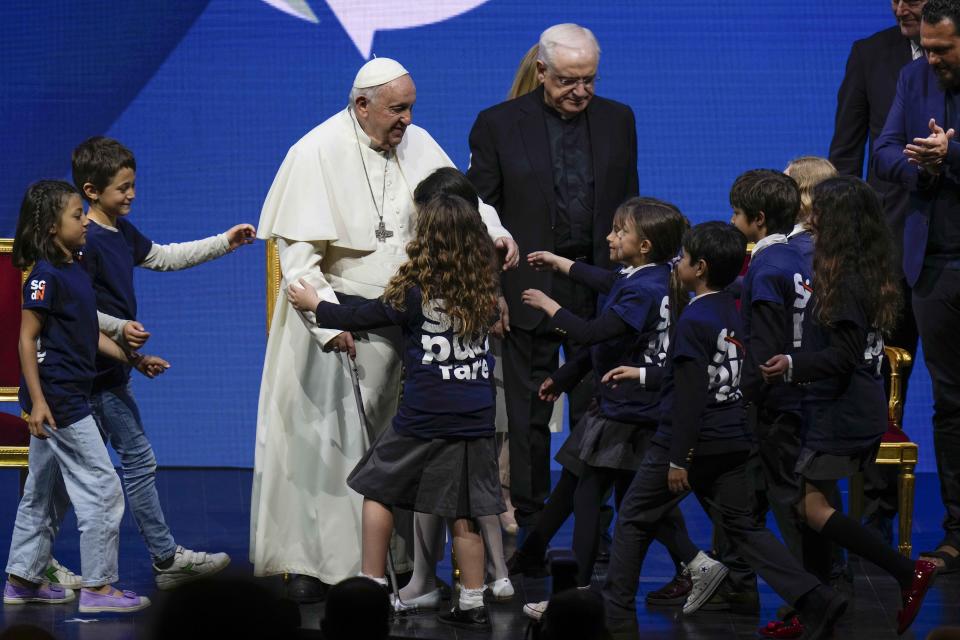 Pope Francis greets kids at the end of a conference to discuss the "demographic winter" and "empty cribs" problem Italy is facing. Panel introduced by Gigi De Palo, president of Birth Rate Foundation, at Auditorium della Conciliazione, in Rome, Friday, May 12, 2023. (AP Photo/Alessandra Tarantino)