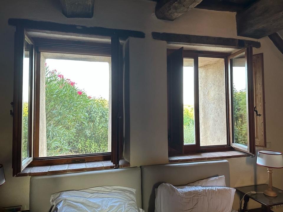 Two open windows in a bedroom.