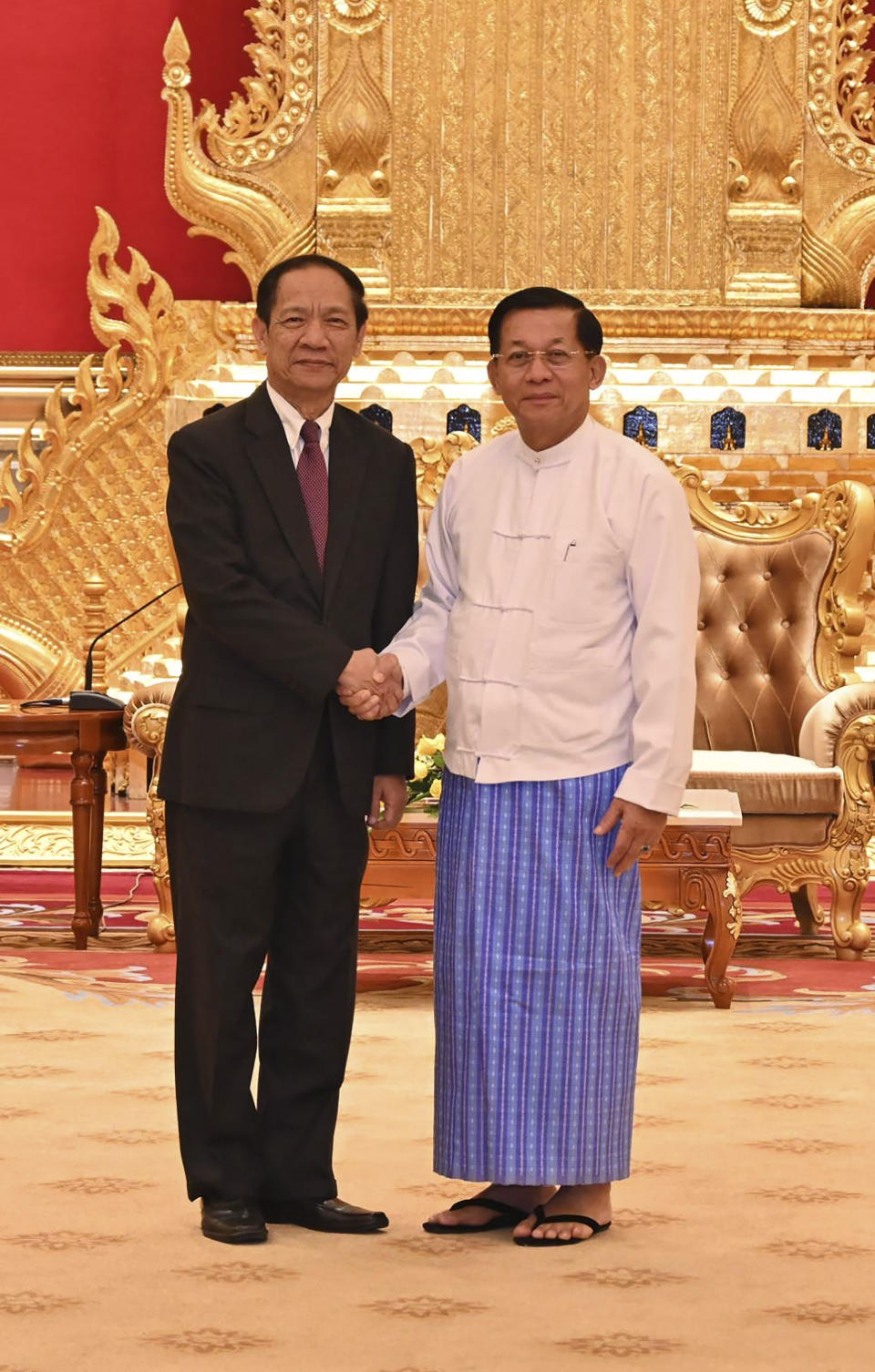 In this photo released from Myanmar Military True News Information Team, Min Aung Hlaing, right, the head of ruling military council, shakes hand with Alounkeo Kittikhoun, left, special envoy of ASEAN Chairman, during their meeting Wednesday, Jan. 10, 2024, in Naypyitaw, Myanmar. A veteran Laotian diplomat recently appointed the Association of Southeast Asian Nations' special envoy to Myanmar, has arrived on his first mission to the strife-torn nation. (The Military True News Information Team via AP)