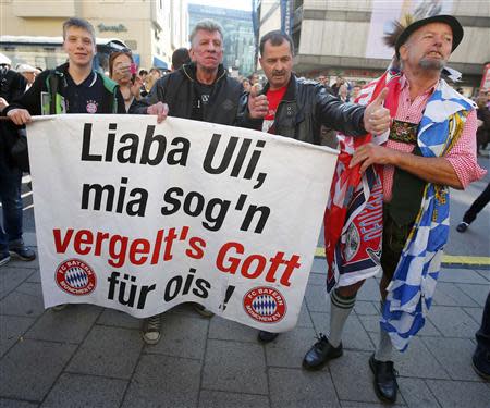 Supporters of Bayern Munich President Uli Hoeness hold a banner reading in Bavarian dialect 'Dear Uli, We say thank you for everything', gather outside the regional court in Munich March 13, 2014. A German court convicted Hoeness of tax evasion on Thursday and sentenced the soccer manager who turned Bayern Munich into one of the world's most successful clubs to three years and six months in jail. REUTERS/Michael Dalder