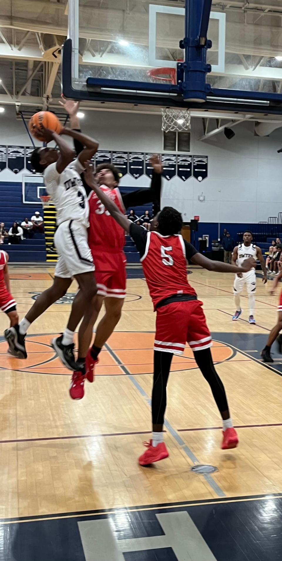 Dwyer's Bobby Gilbert (left) drives for a layup against Southridge's Luke Bello and Quincy Douby during the Panthers' 72-49 victory Thursday night.