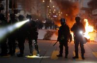 Police officers stand next to a burning barricade during an anti-government protest in Hong Kong China