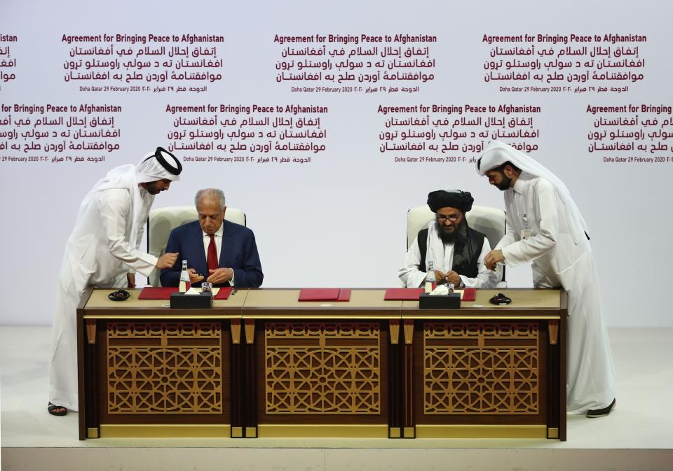 U.S. envoy Zalmay Khalilzad, left, and Taliban co-founder Mullah Abdul Ghani Baradar sign a peace agreement in Doha, Qatar, on February 29, 2020.