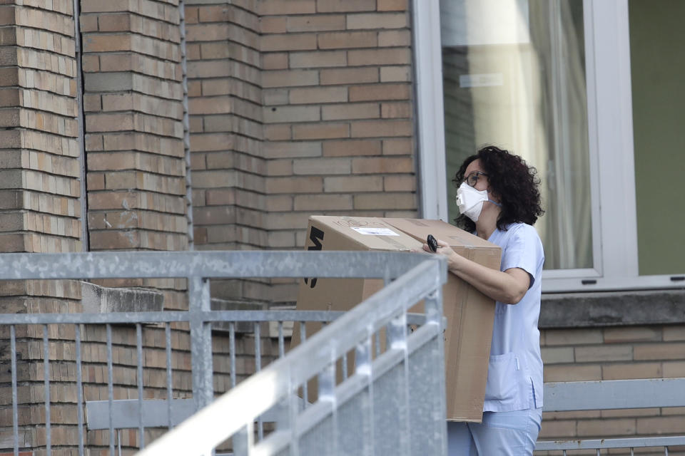 A nurse carries a box into the hospital of Codogno, near Lodi in Northern Italy, Friday, Feb. 21,2020. Health officials reported the country's first cases of contagion of COVID-19 in people who had not been in China. The hospital in Codogno is one of the hospitals - along with specialized Sacco Hospital in Milan - which is hosting the infected persons and the people that were in contact with them and are being isolated. (AP Photo/Luca Bruno)