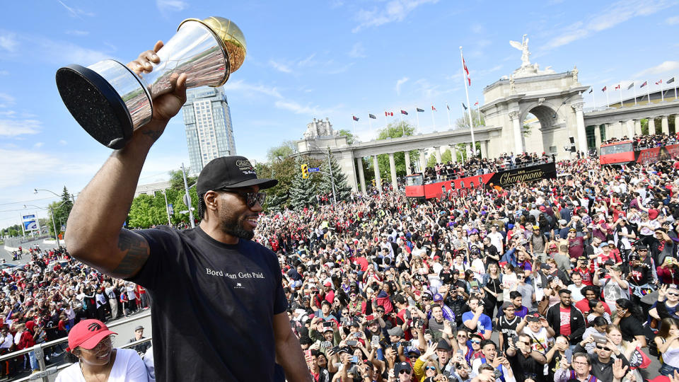 Toronto Raptors forward Kawhi Leonard holds his playoffs MVP trophy as he celebrates during the championship parade. THE CANADIAN PRESS/Frank Gunn