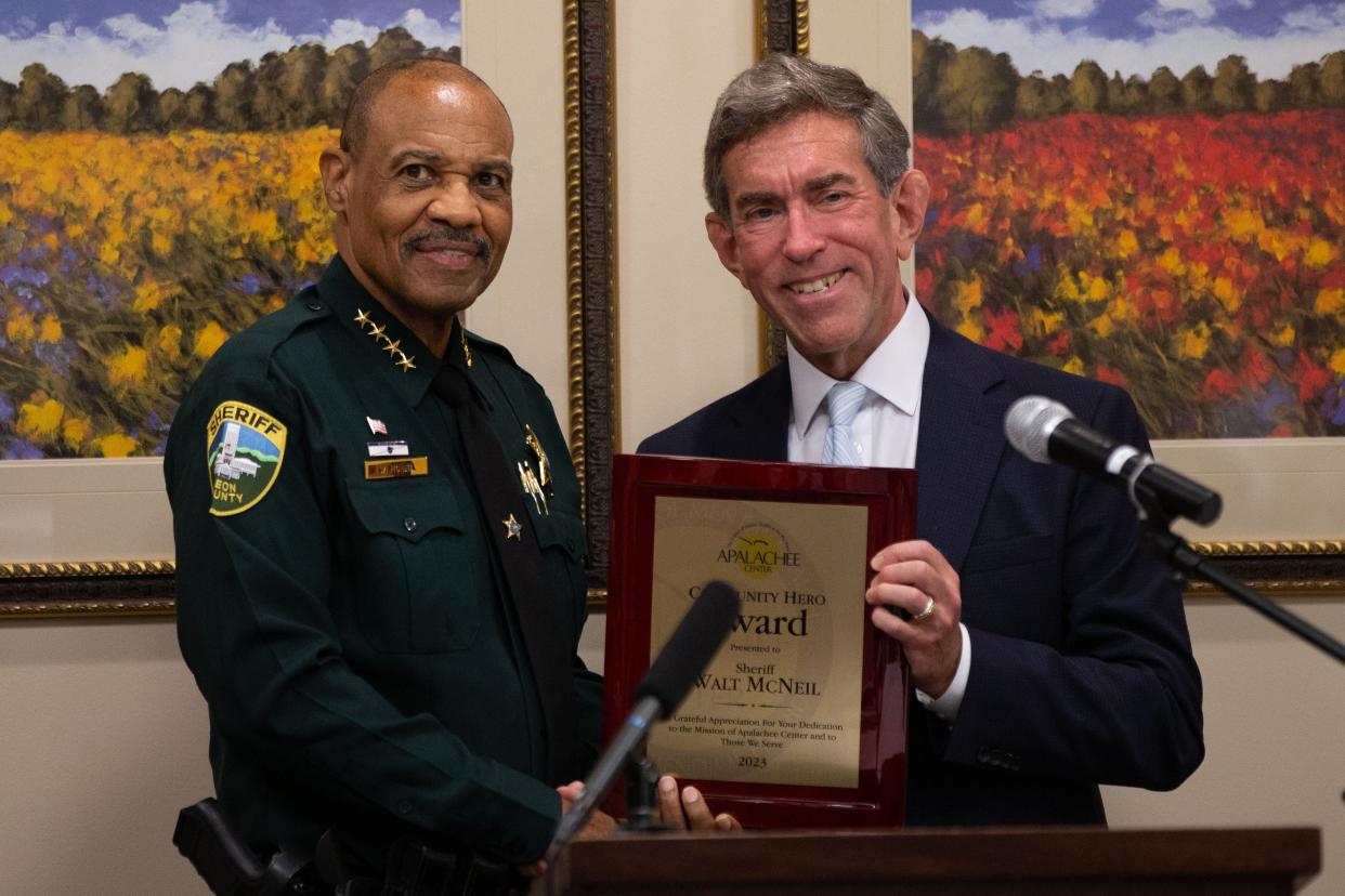President and CEO of the Apalachee Center Jay Reeve, right, presents Sheriff Walt McNeil with a Community Hero award from the Apalachee Center on Monday, July 31, 2023.