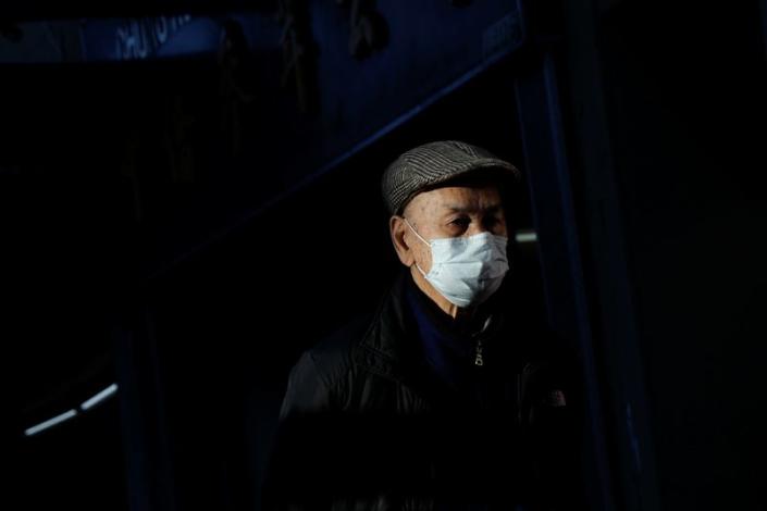 A man wearing a face mask walks through the Chinatown section of San Francisco, California