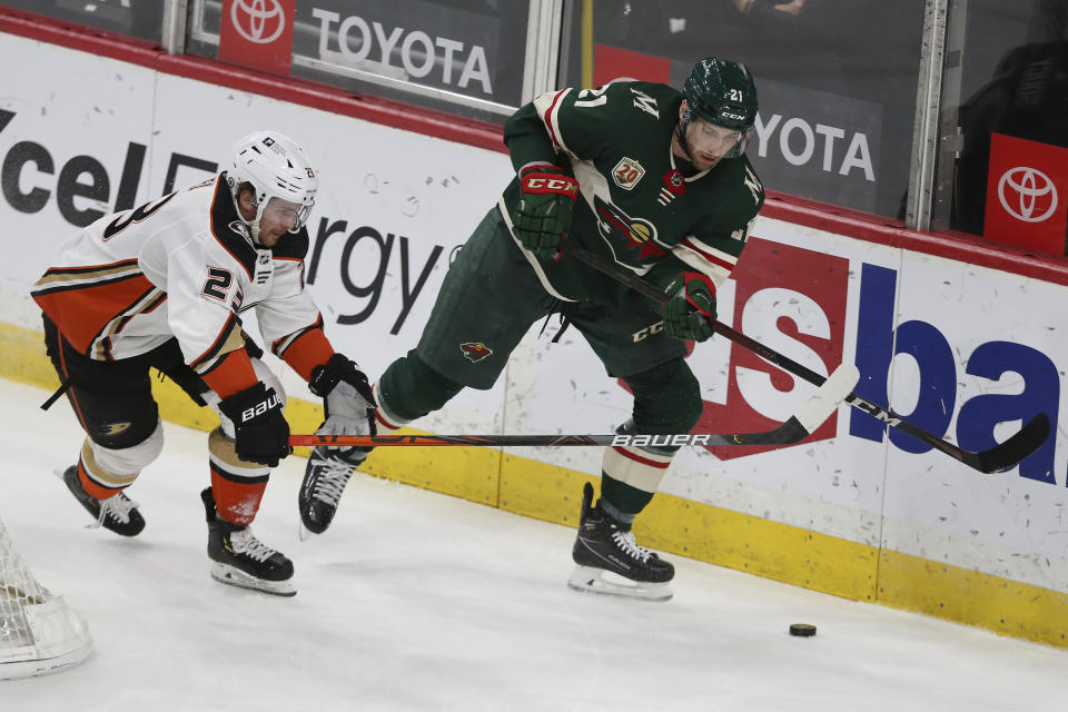 Minnesota Wild's Carson Soucy (21} goes after the puck against Anaheim Ducks' Sam Steel (23) during the first period of an NHL hockey game Friday, May 7, 2021, in St. Paul, Minn. (AP Photo/Stacy Bengs)