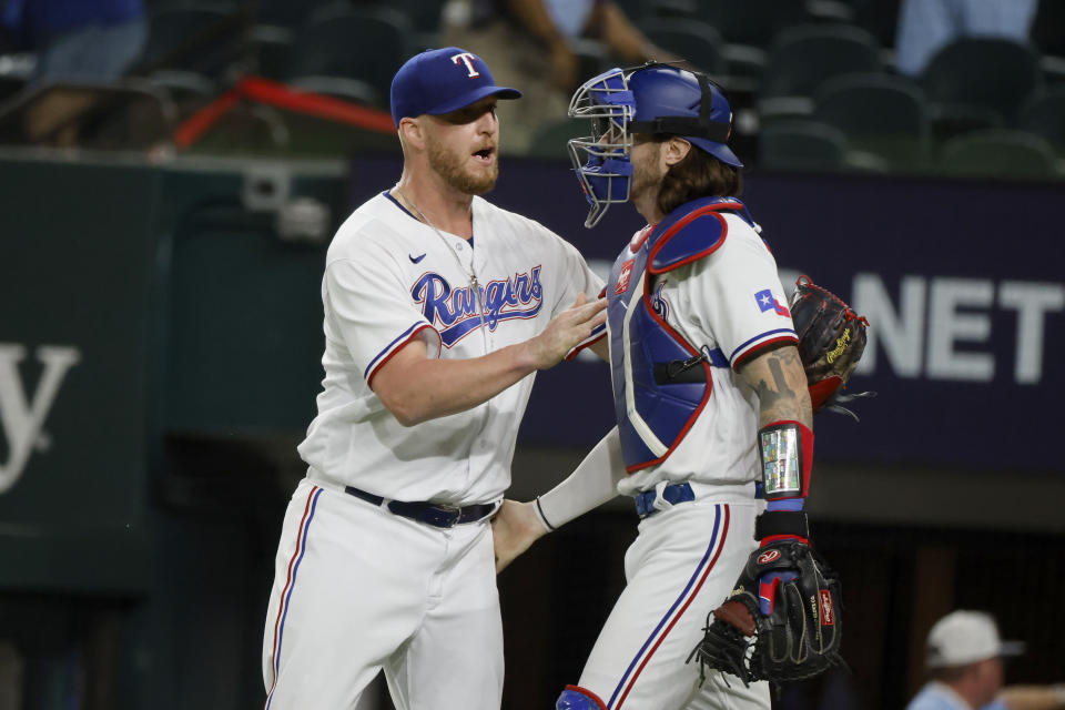 Texas Rangers relief pitcher Will Smith, left, and catcher Jonah Heim (28) celebrate after they defeated the Arizona Diamondbacks during a baseball game against the Texas Rangers, Tuesday, May 2, 2023, in Arlington, Texas. (AP Photo/Michael Ainsworth)