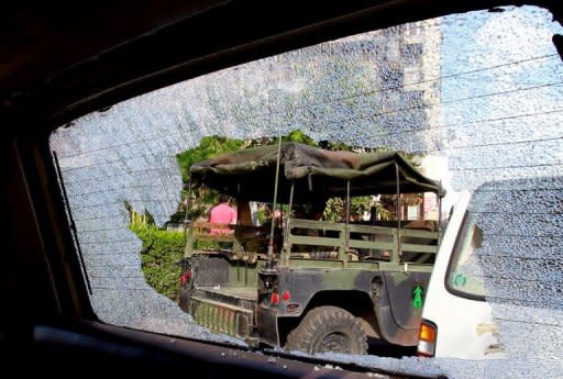 A Lebanese army jeep is seen through the shattered windscreen of a car following overnight clashes in Beirut as violence spills over from Syria