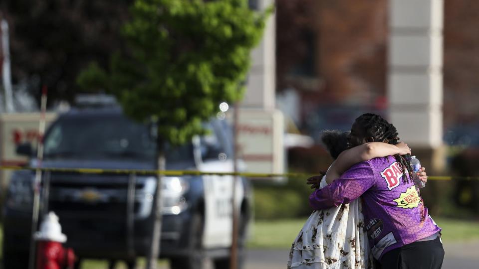 People hug outside the scene after a shooting at a supermarket on Saturday, May 14, 2022, in Buffalo, N.Y.