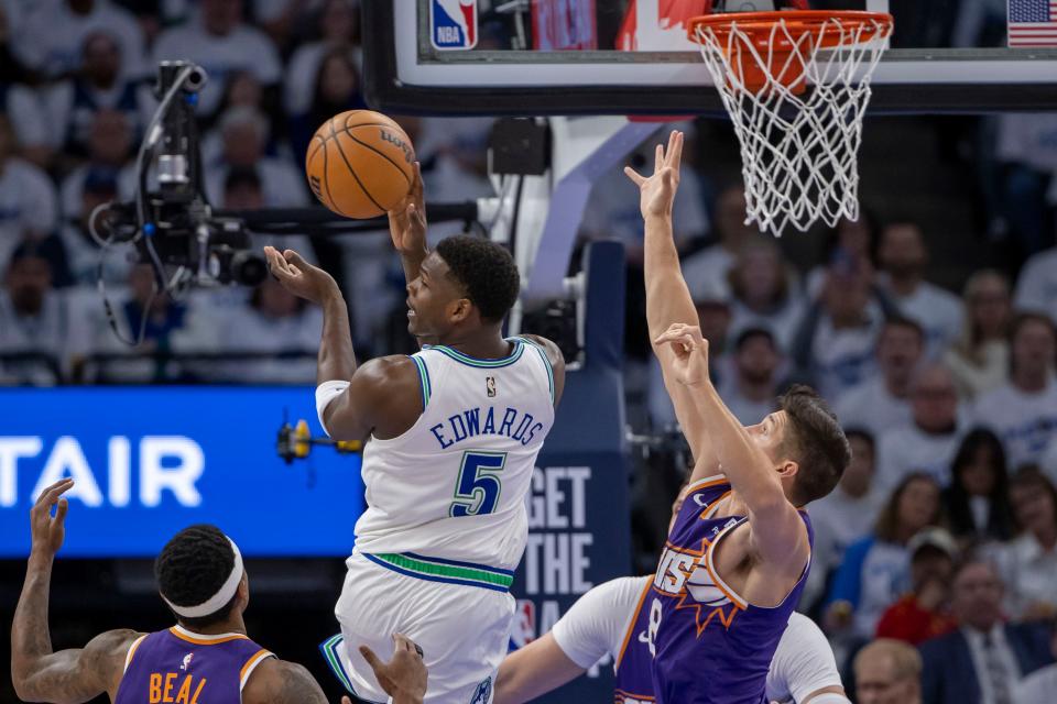 Minnesota Timberwolves guard Anthony Edwards (5) drives to the basket and passes the ball past Phoenix Suns guard Grayson Allen (8) in the first half during game one of the first round for the 2024 NBA playoffs at Target Center.