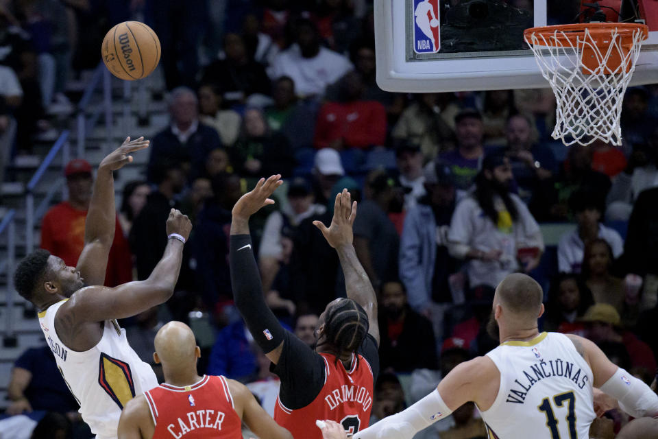 New Orleans Pelicans forward Zion Williamson, left, shoots against Chicago Bulls guard Jevon Carter and center Andre Drummond during the first half of an NBA basketball game in New Orleans, Sunday, Feb. 25, 2024. (AP Photo/Matthew Hinton)