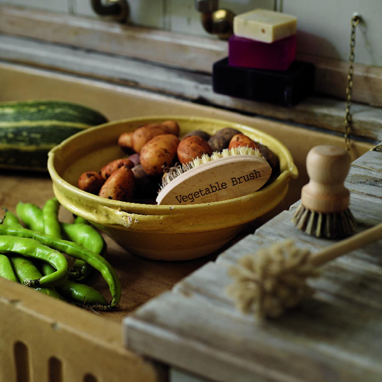  A bowl of sweet potatoes in a kitchen sink. 