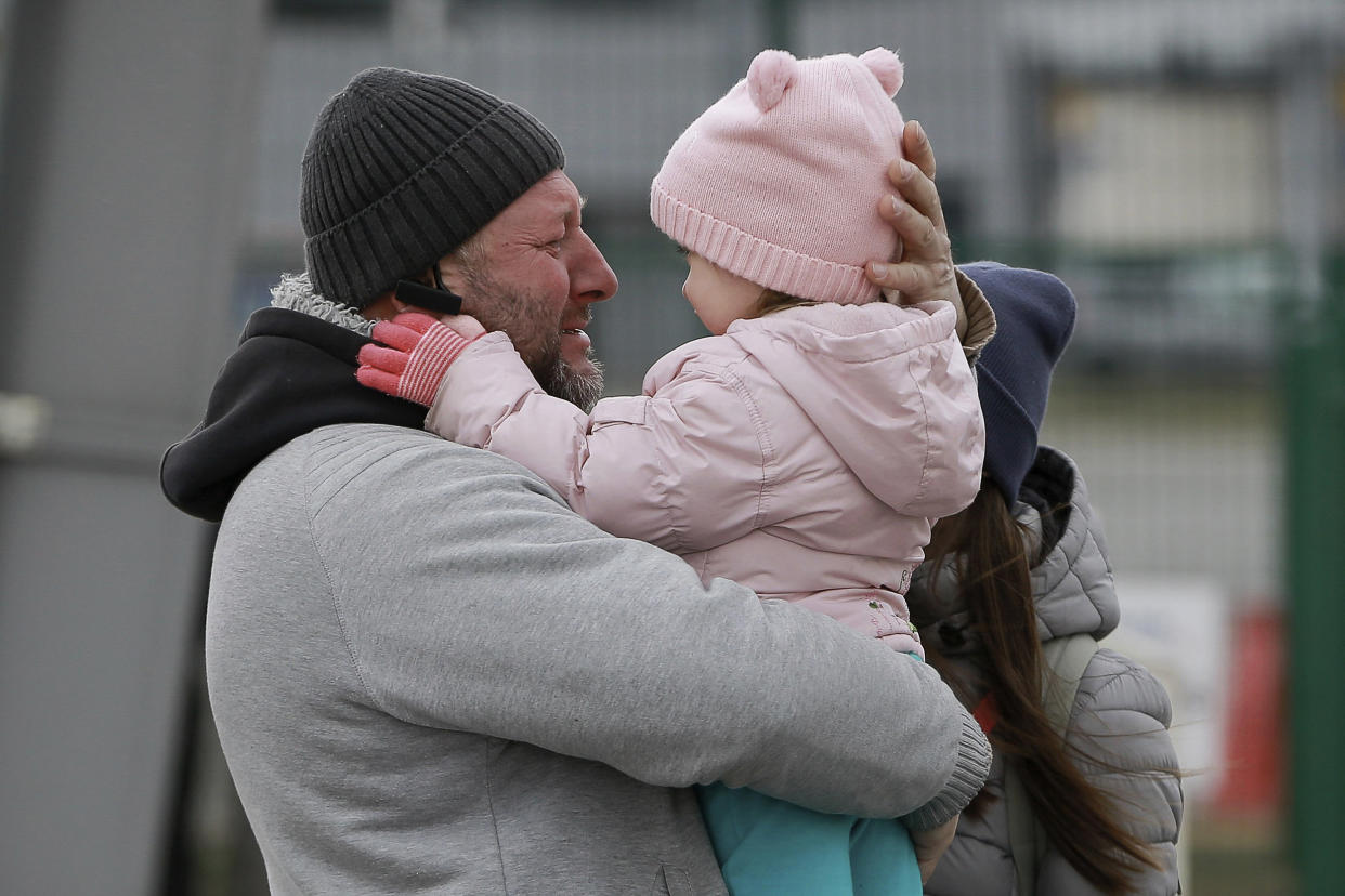 Image: A father hugs his daughter as the family reunite after fleeing conflict in Ukraine, at the Medyka border crossing, in Poland on Feb. 27, 2022. (Visar Kryeziu / AP)