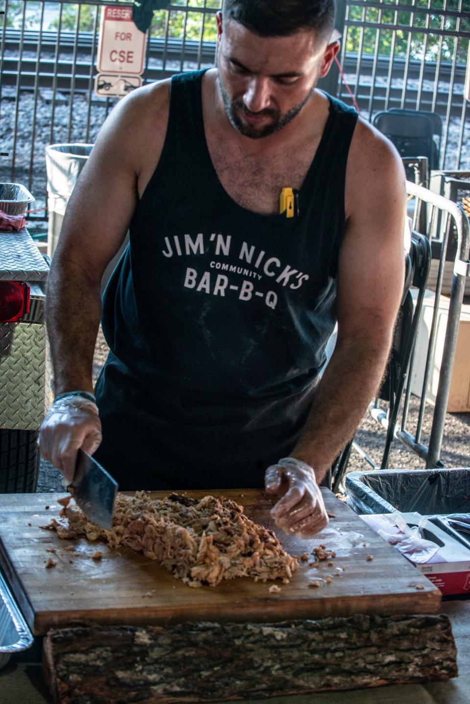 Jim 'N Nick's prepares barbecue for sale during Hog Days of Summer BBQ & Music Festival in downtown Montgomery at the Union Station Train Shed on Saturday, Aug. 17, 2019.