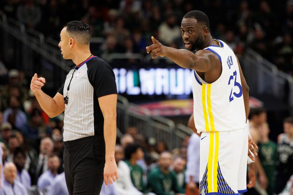 Golden State Warriors forward Draymond Green points out a fan in the stands to a referee during the third quarter against the Milwaukee Bucks.