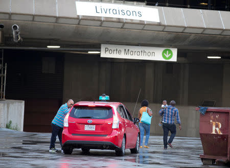 A family gets out of a taxi at Olympic Stadium, which is being used as temporary housing for asylum seekers, in Montreal, Quebec, Canada August 2, 2017. REUTERS/Christinne Muschi