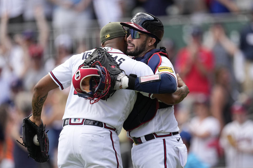 Atlanta Braves catcher Travis d'Arnaud embraces relief pitcher Raisel Iglesias after the final out in the ninth inning of a baseball game against the Seattle Mariners, Sunday, May 21, 2023, in Atlanta. (AP Photo/John Bazemore)