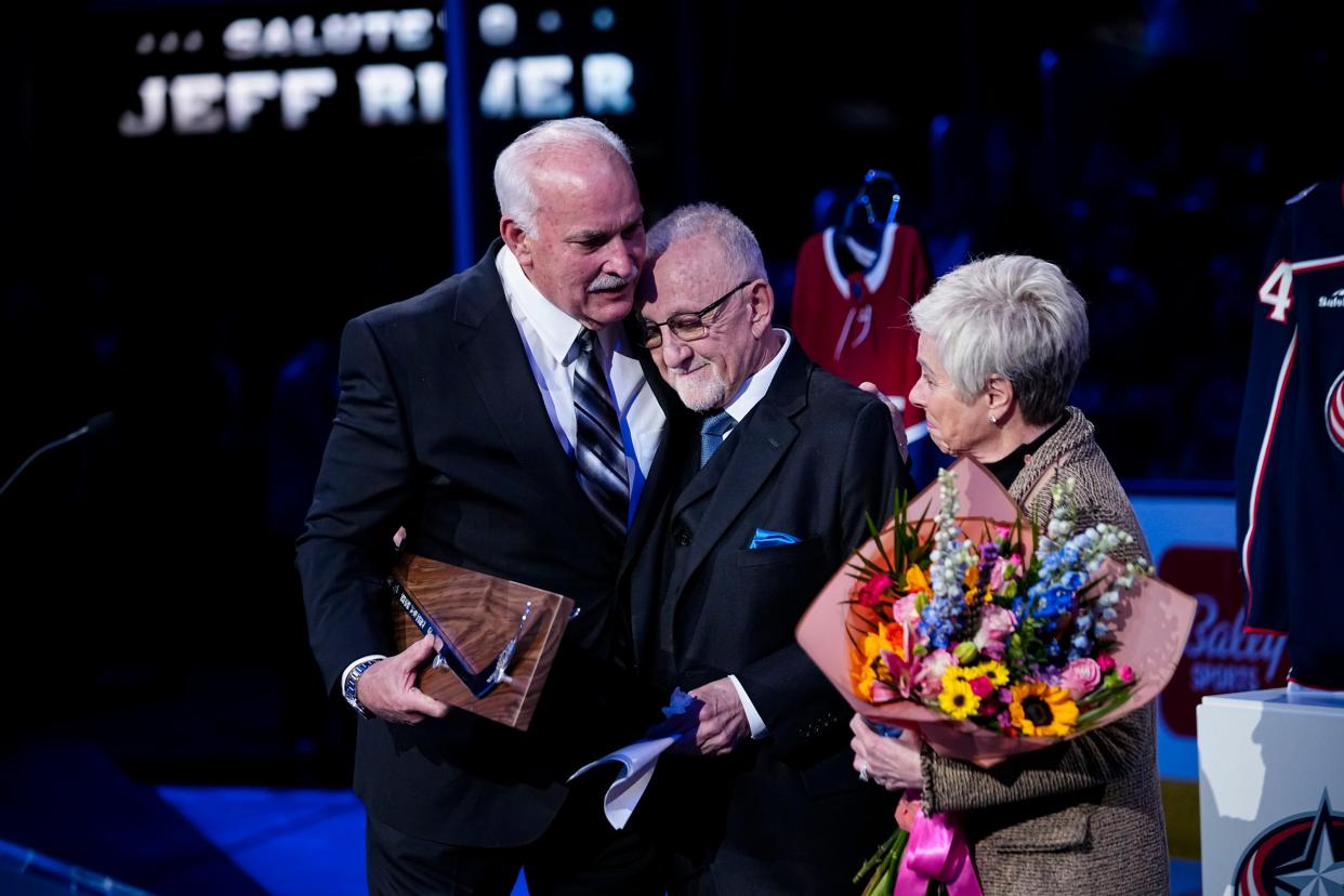 Mar 30, 2024; Columbus, Ohio, USA; Jeff Rimer get a hug from team president John Davidson while standing beside his wife, Ferrel, as the legendary broadcaster is honored prior to the NHL hockey game between the Columbus Blue Jackets and the Pittsburgh Penguins at Nationwide Arena. Rimer is retiring at the end of the season.
