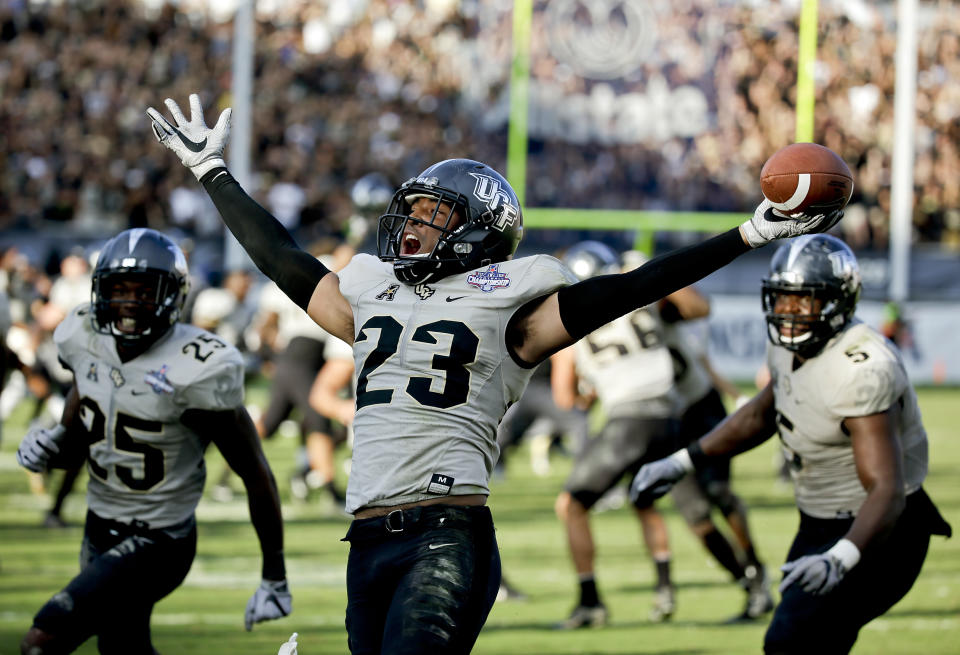 Central Florida defensive back Tre Neal (23) celebrates after intercepting a Memphis pass to end the American Athletic Conference championship NCAA college football game, Saturday, Dec. 2, 2017, in Orlando, Fla. Central Florida won in overtime 62-55. (AP Photo/John Raoux)