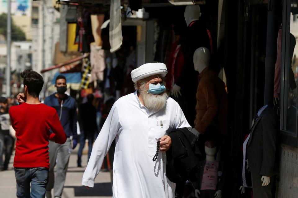 A man wears a protective face mask as he walks along the main market in downtown after the government eased the restrictions on movement aimed at containing the spread of the coronavirus disease (COVID-19), in Amman, Jordan April 29, 2020. REUTERS/Muhammad Hamed